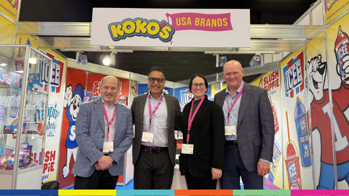People standing together at a booth at a candy conference